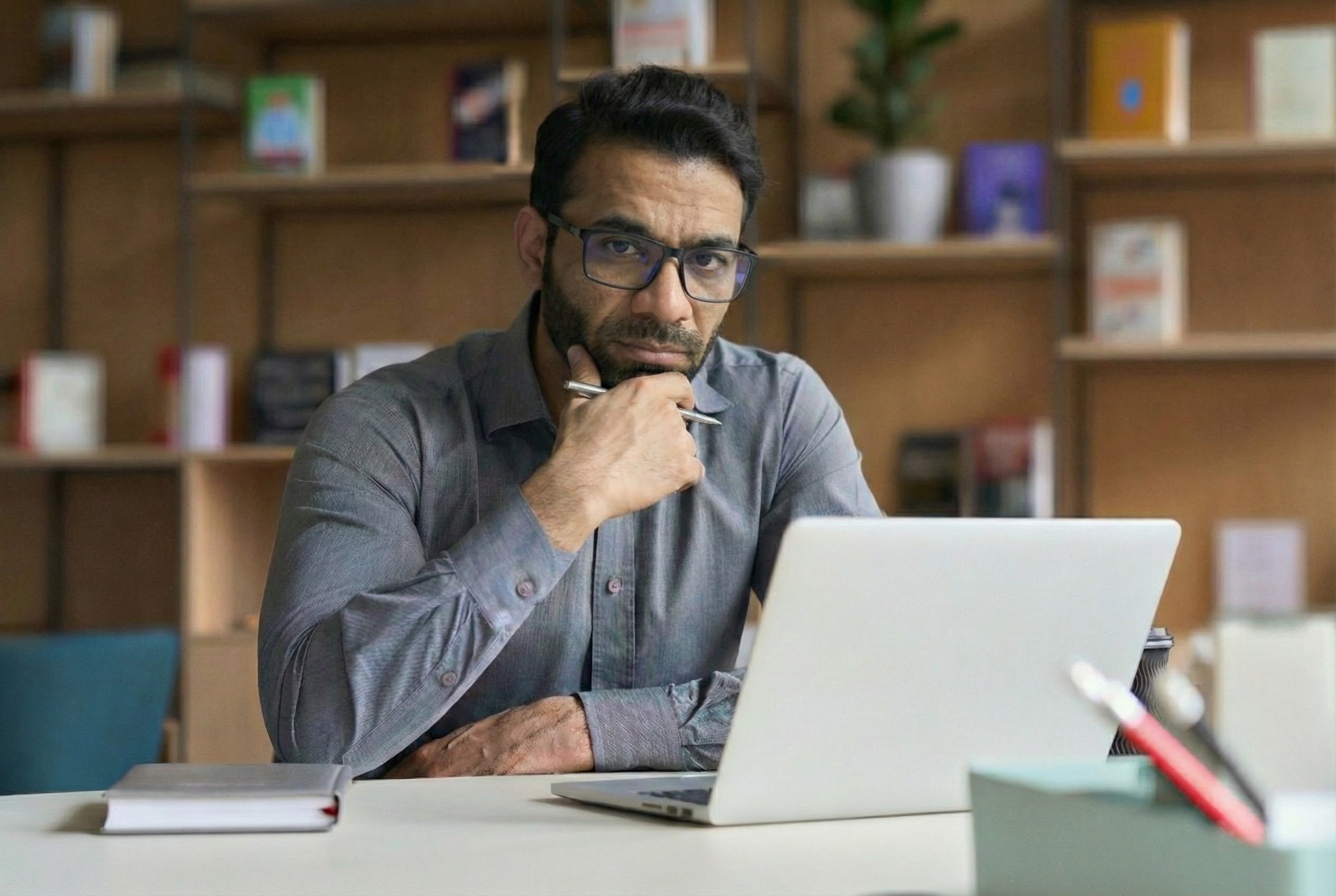 man at desk with open laptop